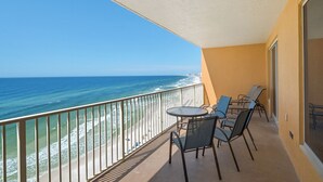A balcony with a view of the ocean, a table, and two chairs. - Treasure Island 1003 (Panama City Beach)