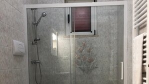 A bathroom with a shower, toilet, and sink.