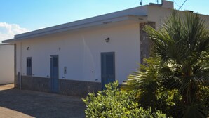 A building with a flat roof, three blue doors, and a small antenna on the roof.