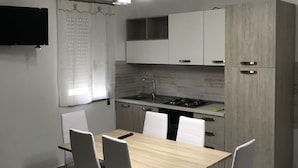 A modern kitchen with a wooden countertop, white cabinets, and a built-in stove. - Residence Lamezia Golfo (Lamezia Golfo)