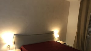A bedroom with a bed, nightstands, and a lamp. - Residence Lamezia Golfo (Lamezia Golfo)