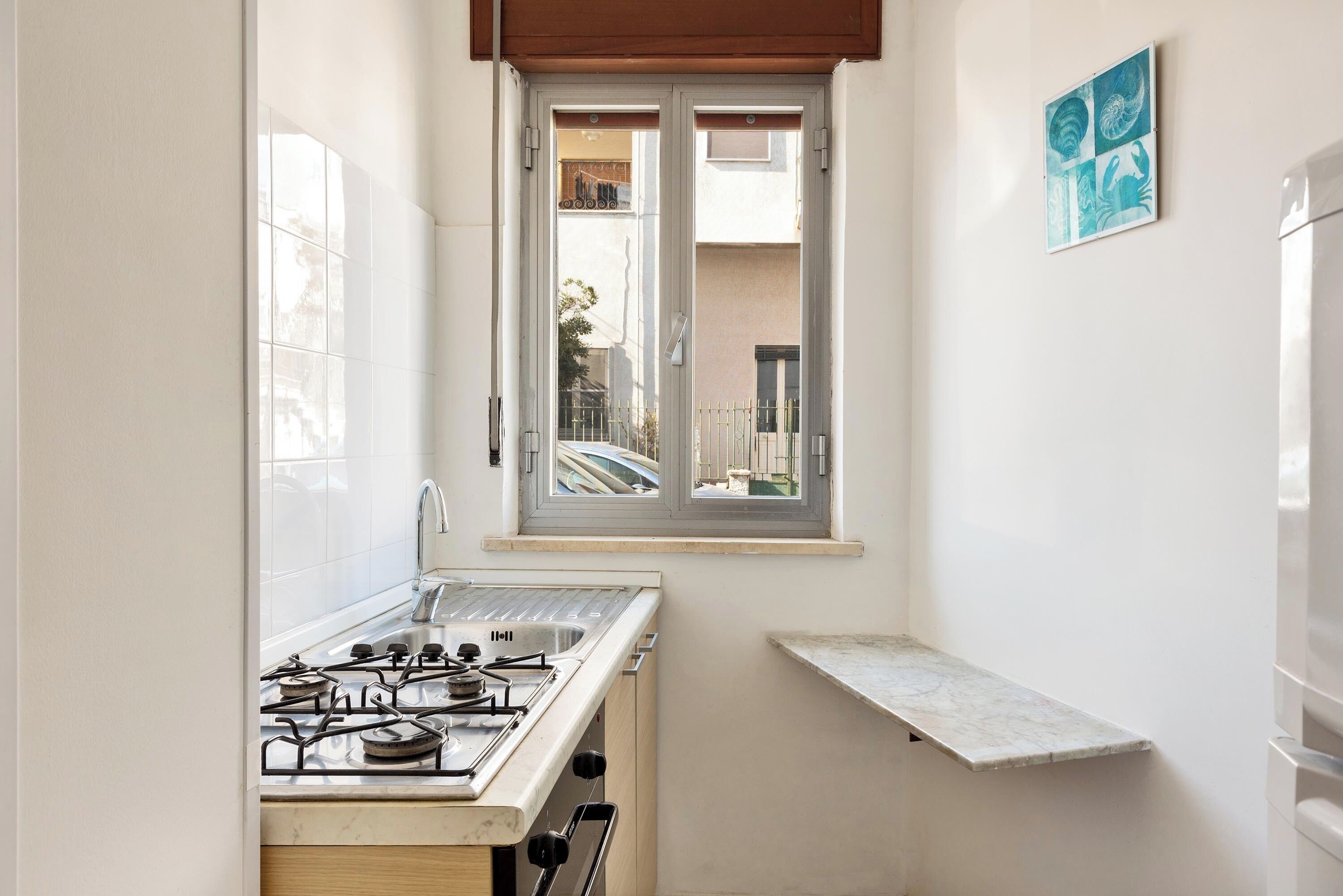 A compact kitchen with a gas stove, a window, and a small countertop.