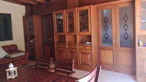 Un interior de madera con una mesa de comedor, sillas, un sofá y armarios empotrados.