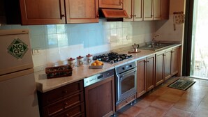 Una cocina con armarios de madera, estufa de acero inoxidable, lavavajillas y refrigerador.