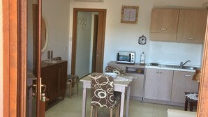 Una cocina compacta con microondas, tostadora y lavabo.