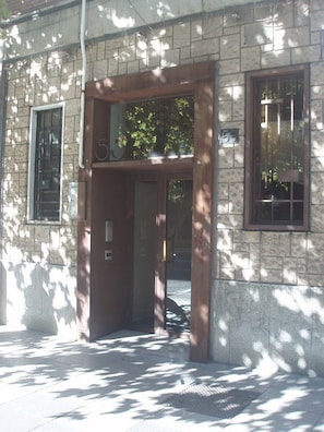 Stunning building facade with a welcoming entrance, featuring a door and a glass panel, set against a natural backdrop.