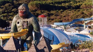 En vattenpark med en stor gorilla-staty, vattenrutschkanor och en pool.