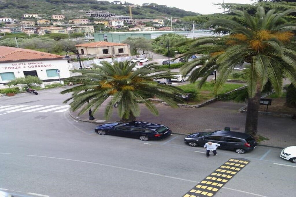 Una vista di una strada con un edificio con la scritta 'Società Sportiva Forza e Coraggio'.