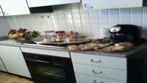 A kitchen with white cabinets, a coffee maker, a fruit bowl, and a toaster. - Freedom apartment (Portovenere)