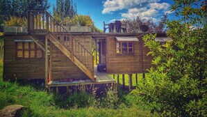 A wooden cabin with a deck, a staircase, and a small porch area. - Cabaña Agrreste Bed & Breakfast (Nemocón)