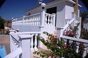 Un bâtiment blanc doté d’un balcon et d’une piscine.