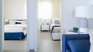 Hotellihuone, jossa on kaksi sänkyä, työpöytä ja tuoli.