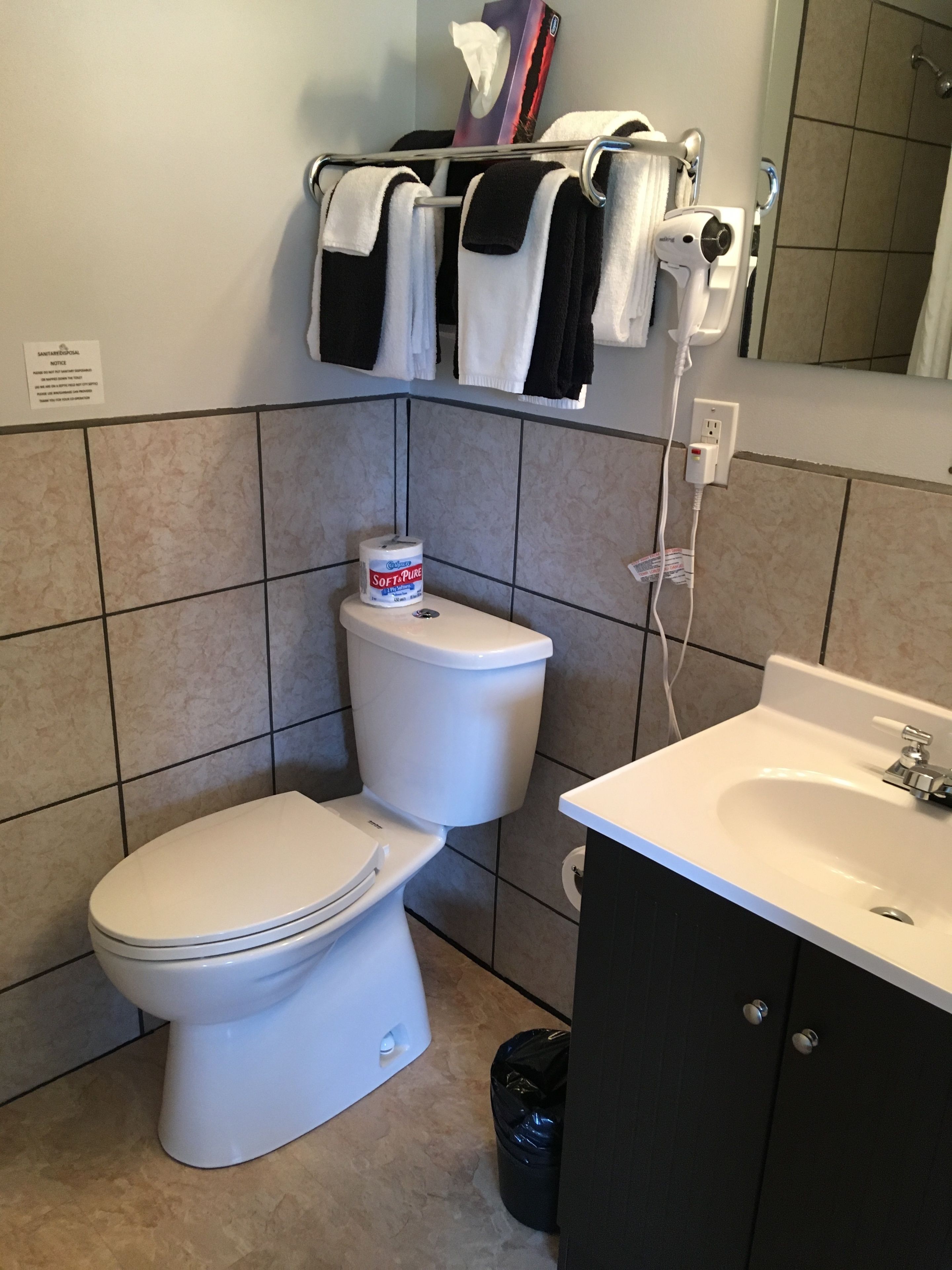 A bathroom with a toilet, a sink, and a towel rack.