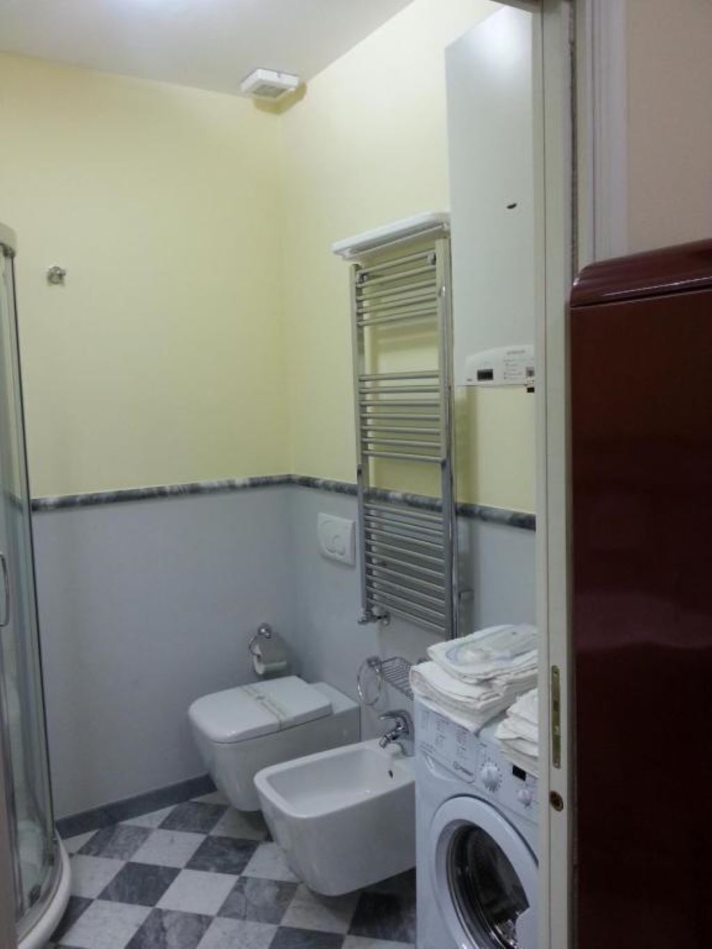 Ein kleines Badezimmer mit Toilette, Bidet und Waschmaschine.