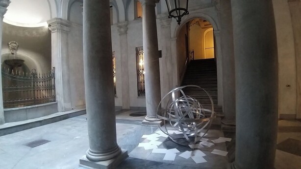 A grand hallway with large columns, a spiral sculpture, and a staircase leading to an upper level. - SMITHS & HERREROS (Codie CIN IT010025C2Q2M67QJW) (Genova)