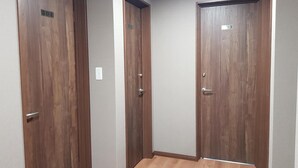 A hallway with three wooden doors, each marked with a number. - Ak Star (Furano)