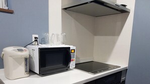 A compact kitchen with a microwave, a rice cooker, and a sink. - Ak Star (Furano)