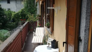 A balcony with white chairs and a table, a wooden door, and a lantern. - Mount N Lake Apartment -Ledro Garda (Ledro)