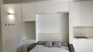 Un dormitorio moderno con cama, mesitas de noche y armarios empotrados.