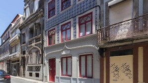A row of multi-story buildings with red-framed windows and balconies.