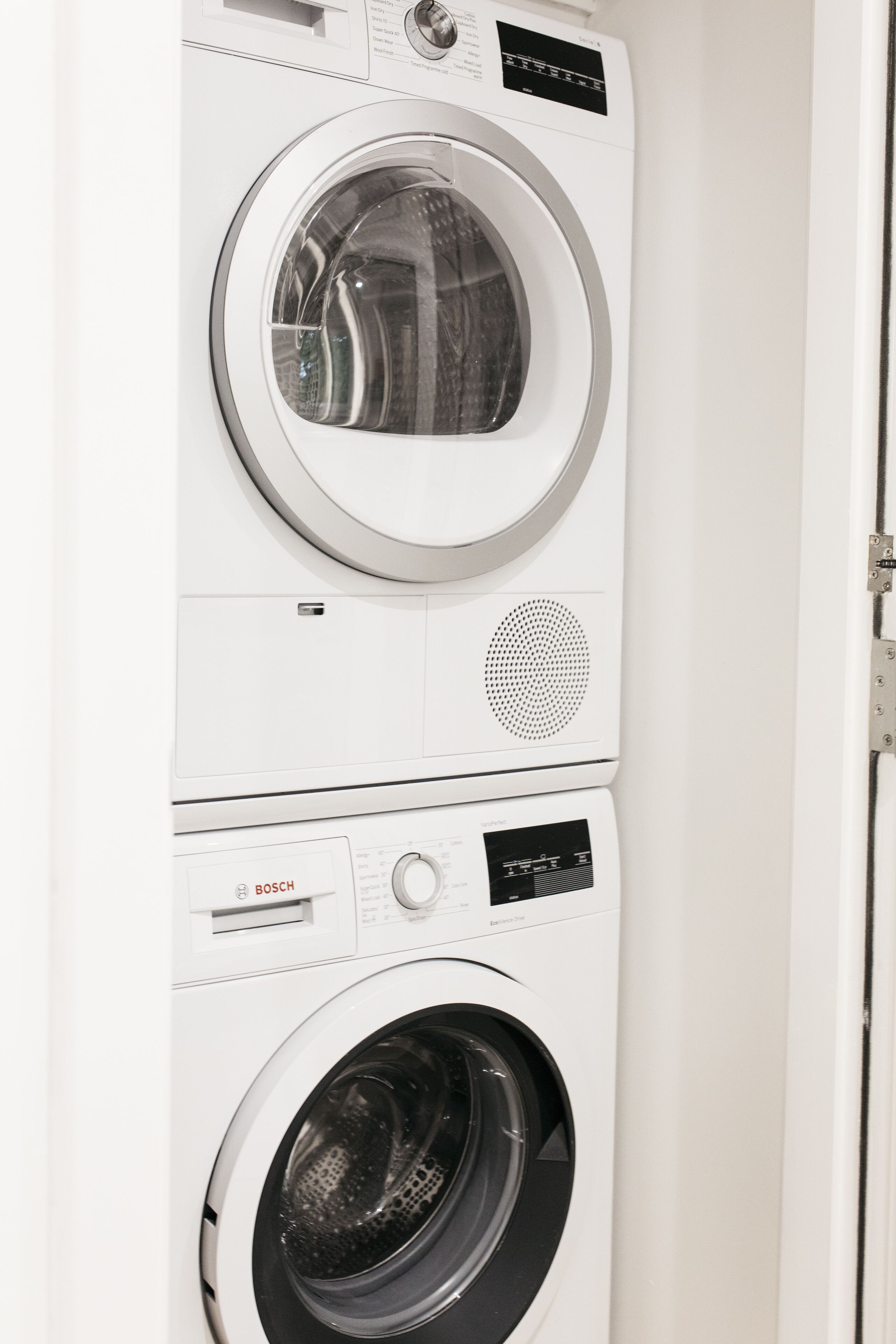 A stacked washer and dryer unit with control panels and a door.