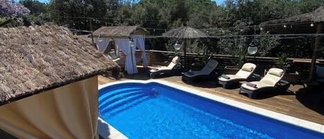 A swimming pool with lounge chairs and a canopy.