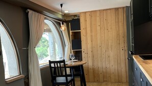 A compact kitchen with a dining area, wooden cabinets, and a built-in TV. - Beautiful studio/apartment with air conditioning and use of pool.  (Begur)