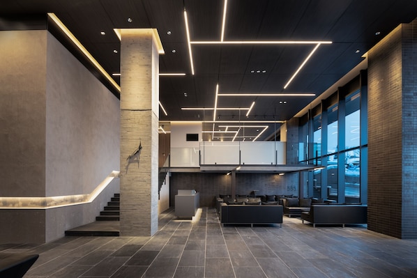 A modern lobby with a staircase, seating area, and large windows. - Sansui Niseko (Kutchan)