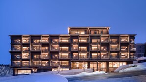 A multi-story hotel with a modern architectural design, featuring balconies and large windows. - Sansui Niseko (Kutchan)