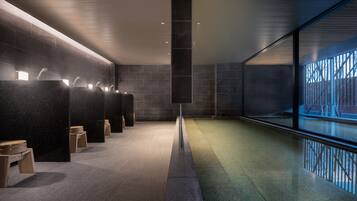 Experience a sleek, modern bathroom with dark rectangular sinks, individual lighting, and a linear design.