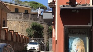 Una calle estrecha con un edificio que muestra un letrero que dice 'Tabacceria'.