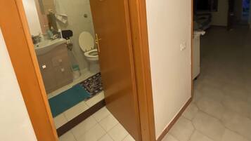 Une salle de bain avec des toilettes, un lavabo et un miroir.