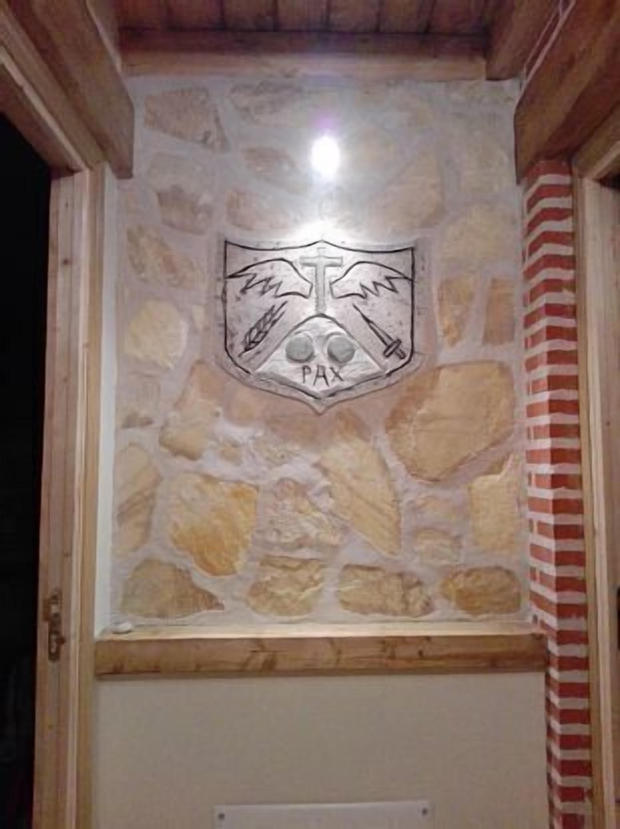 A stone wall with a PAX emblem.