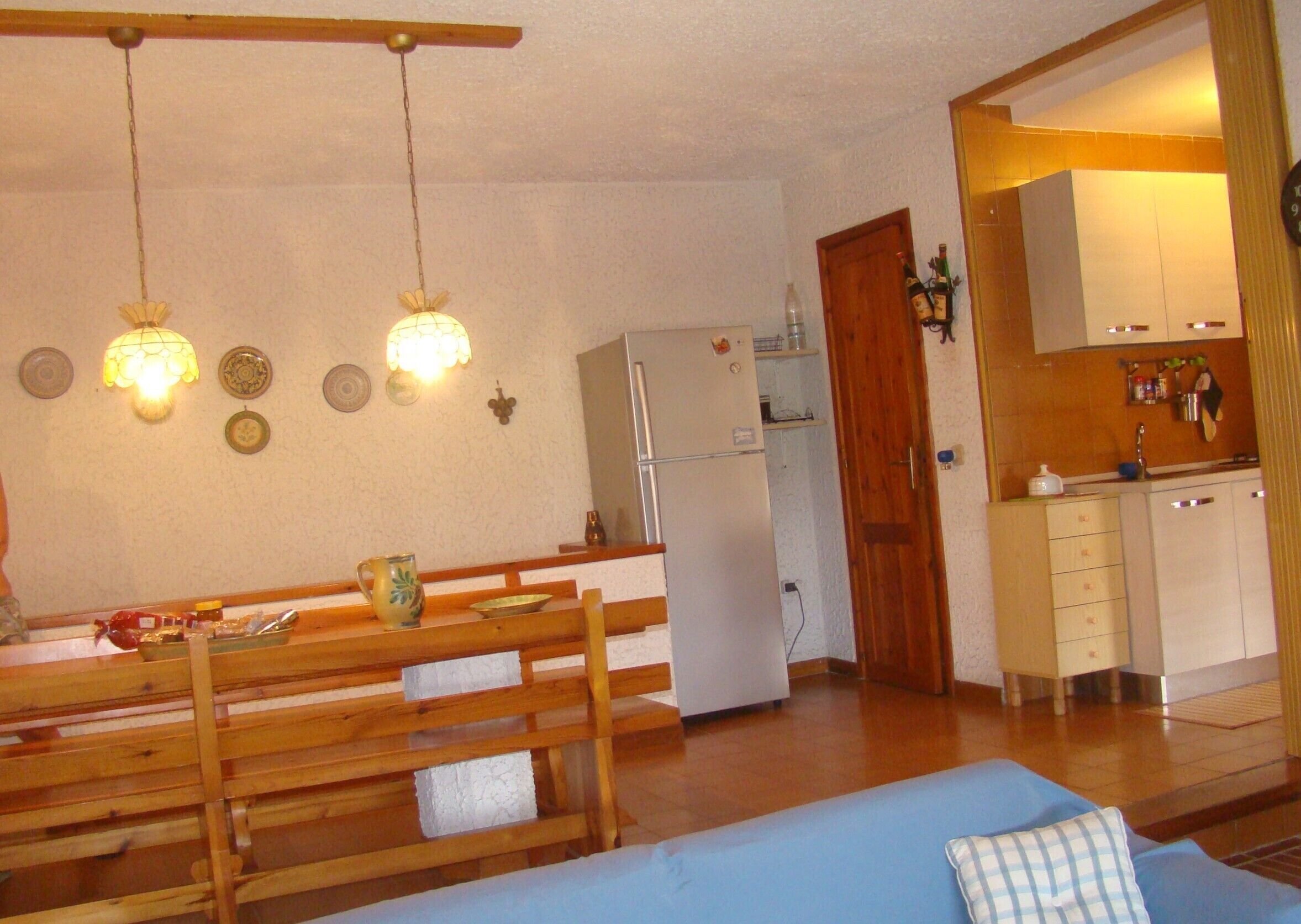 A compact living space with a dining area, kitchenette, and a sofa.