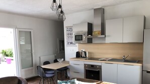 Ett modernt kök med matplats, en soffa och utsikt över omgivningen.