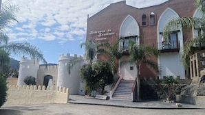 A building with a castle-like facade, a staircase, and a sign that reads 'Bentos de Bentomiz Apartahotel.' - Suite with private jacuzzi in the room (Arenas)