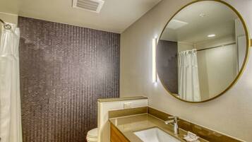A modern bathroom with a shower, toilet, and sink.