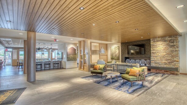A spacious lobby with a wooden ceiling, a stone fireplace, and comfortable seating areas. - Fairfield Inn & Suites by Marriott Appleton (Appleton)
