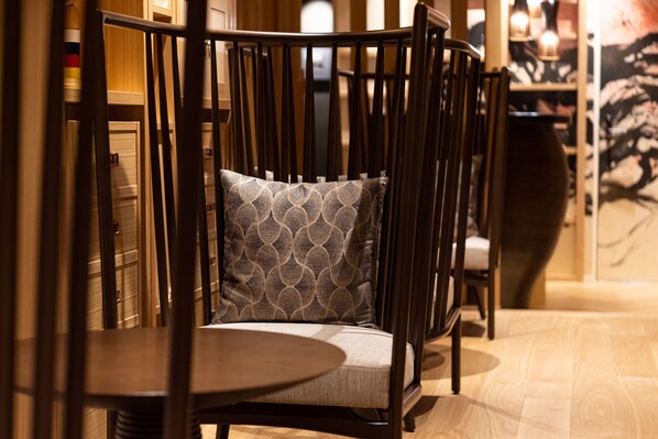 A wooden chair with a patterned cushion in a room with wooden flooring and a table. - Prostyle Ryokan Tokyo Asakusa (Tokyo)