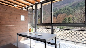 Une cuisine moderne dotée d’une grande fenêtre donnant sur une montagne boisée.