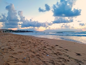 A beach with footprints and scattered debris.