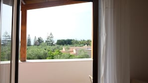 Un balcó amb vistes a vegetació i edificis.