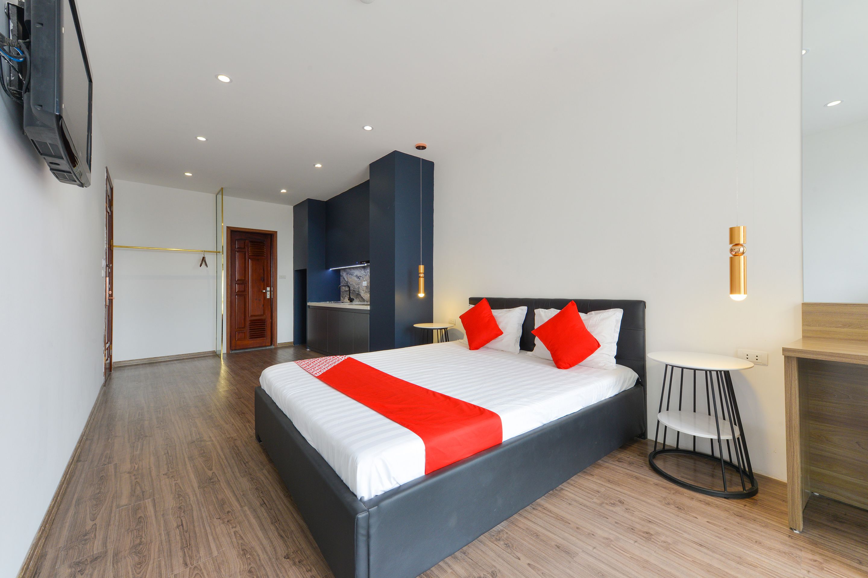 Een moderne hotelkamer met een groot bed, een klein bureau en een aan de muur bevestigde televisie.