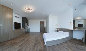 A modern hotel room with a large bed, a built-in desk, a television, and a mirror. - BH Riverside Hotel (Hanoi)