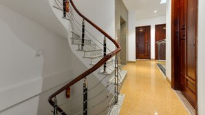 A modern interior with a curved staircase, polished floors, and wooden doors. - BH Riverside Hotel (Hanoi)