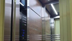 An elevator interior with a control panel displaying floor numbers and a digital clock. - Reikartz Xon Tashkent (Tashkent)