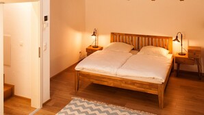 A bedroom with a wooden ceiling, a bed, a nightstand, and a hanging light fixture. - Living in a unique atmosphere near the Europapark Rust (Ettenheim)