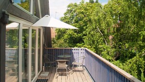 A wooden deck with glass doors, a table, and chairs. - Living in a unique atmosphere near the Europapark Rust (Ettenheim)