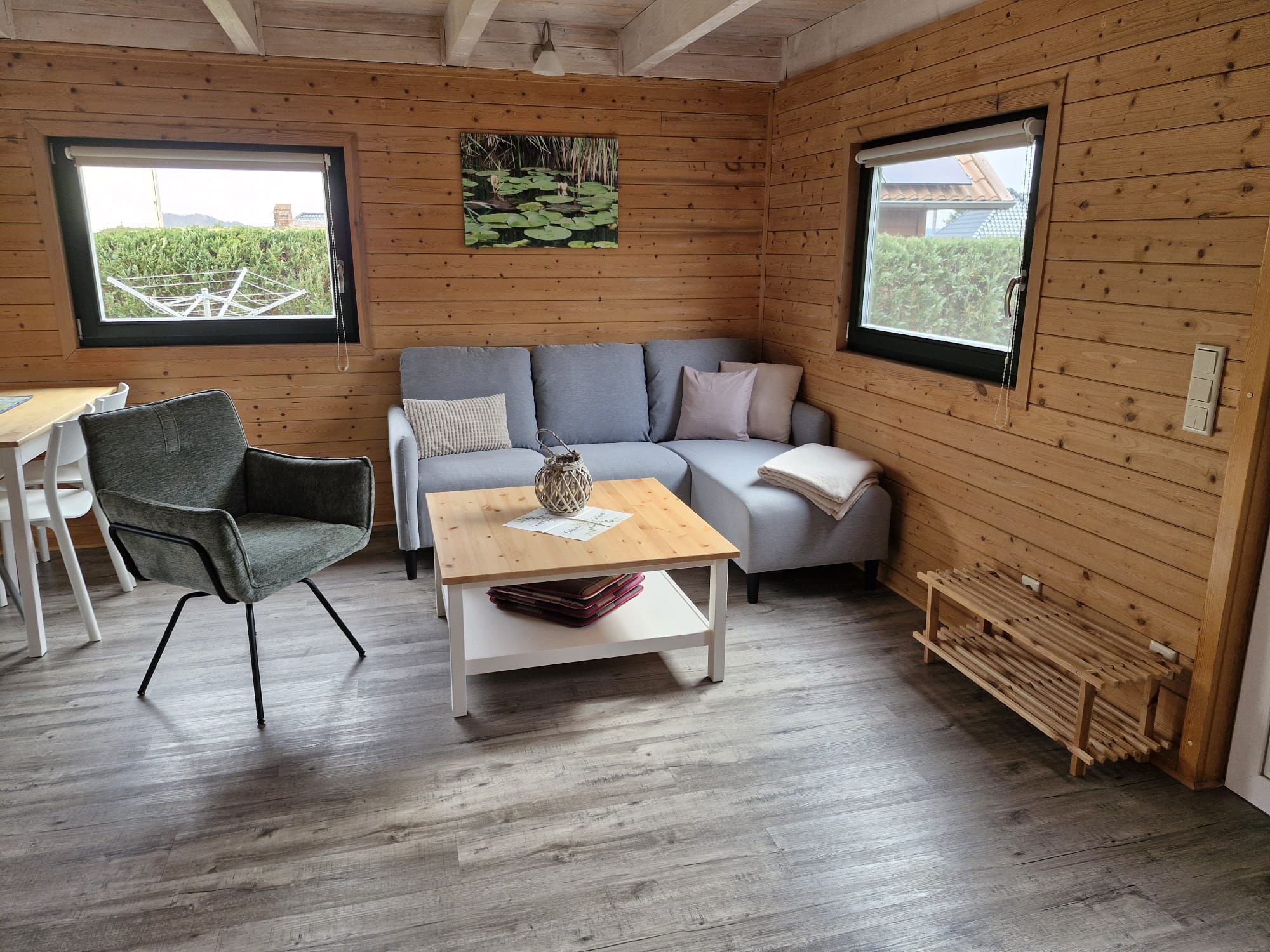 A cozy cabin interior with a gray sofa, a wooden table, and a chair.