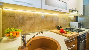 Une cuisine moderne équipée d’un évier encastré, d’un four à micro-ondes et d’une cuisinière à gaz.